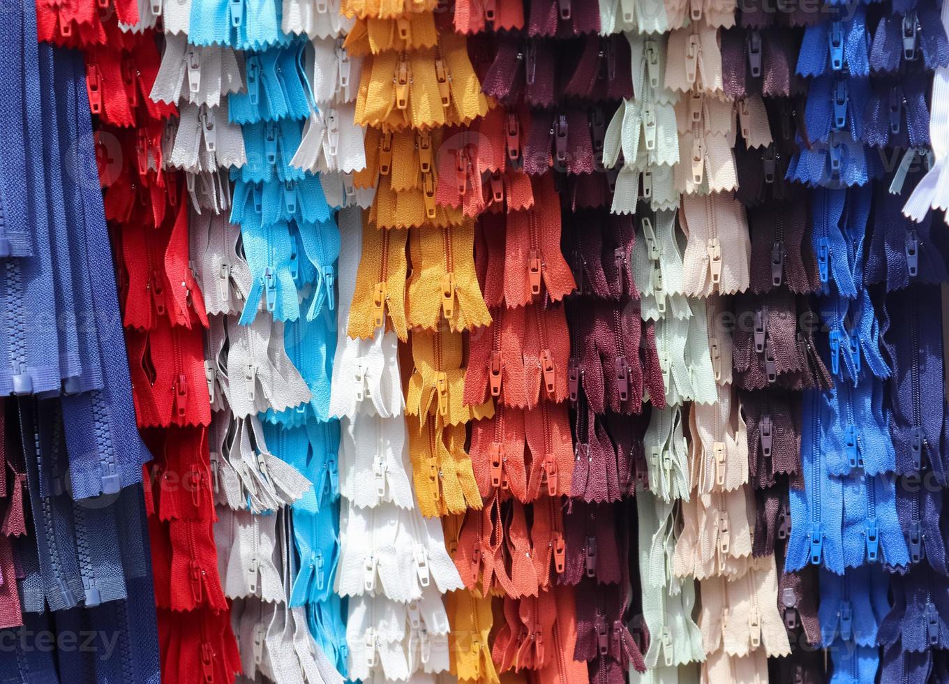 vista de cerca de muestras de cremalleras en diferentes colores encontradas en un mercado de telas. foto