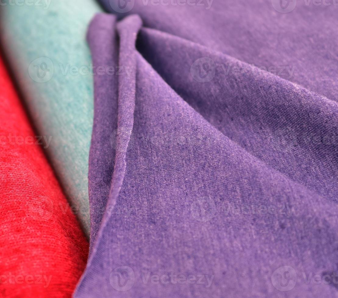 Detailed close up view on samples of cloth and fabrics in different colors found at a fabrics market photo