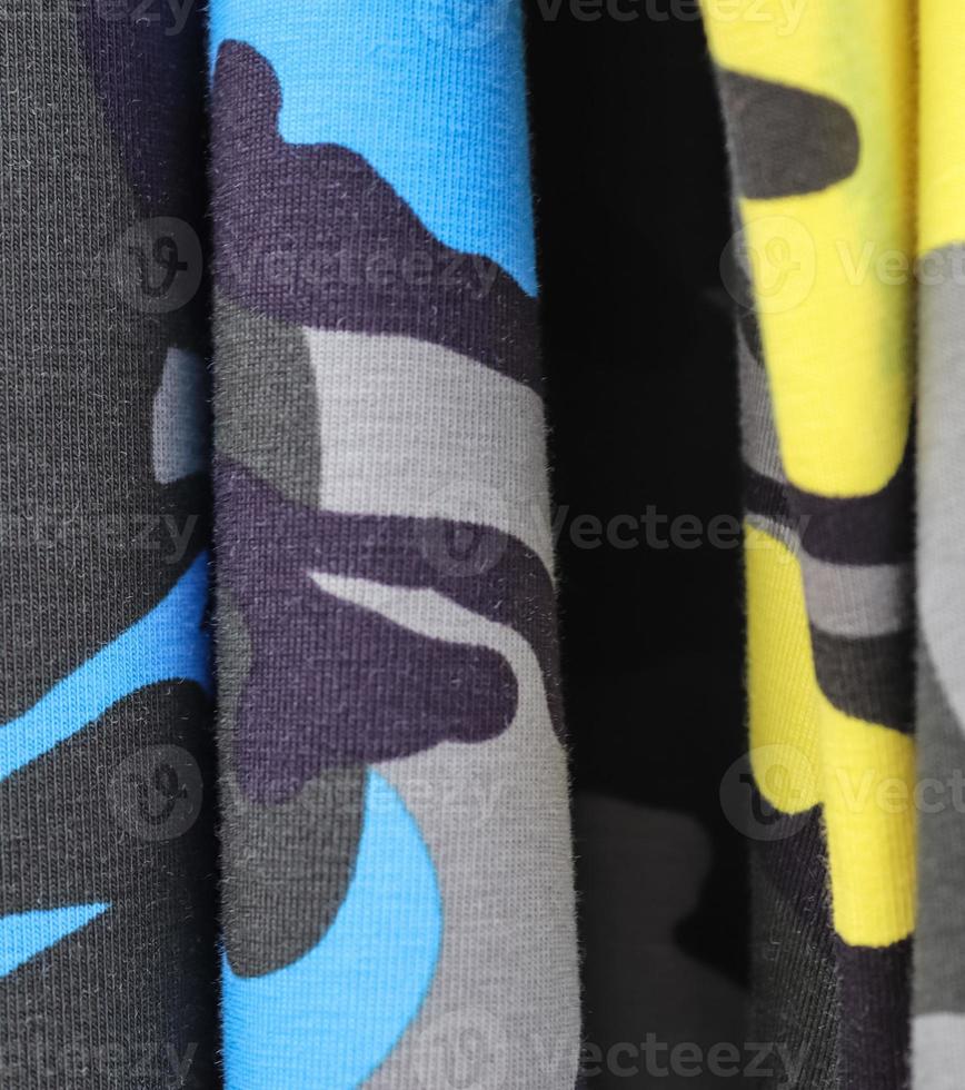 Detailed close up view on samples of cloth and fabrics in different colors found at a fabrics market photo