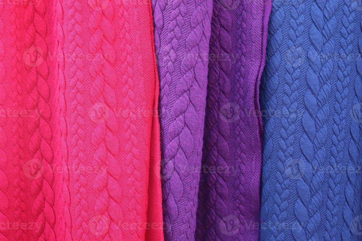 Detailed close up view on samples of cloth and fabrics in different colors found at a fabrics market photo