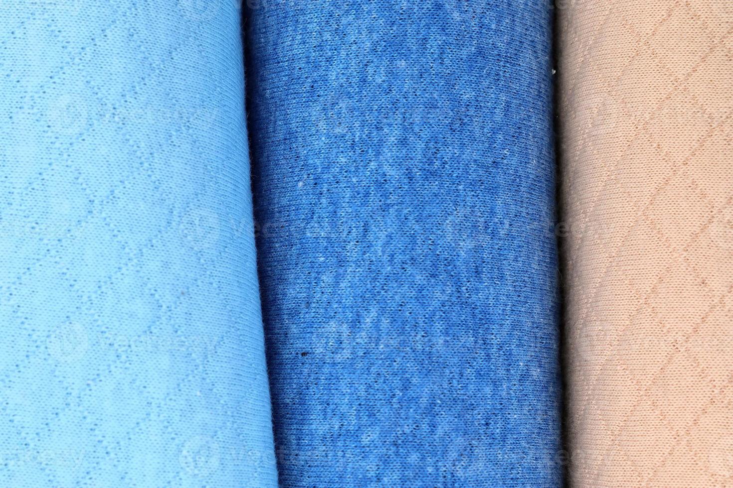Detailed close up view on samples of cloth and fabrics in different colors found at a fabrics market photo