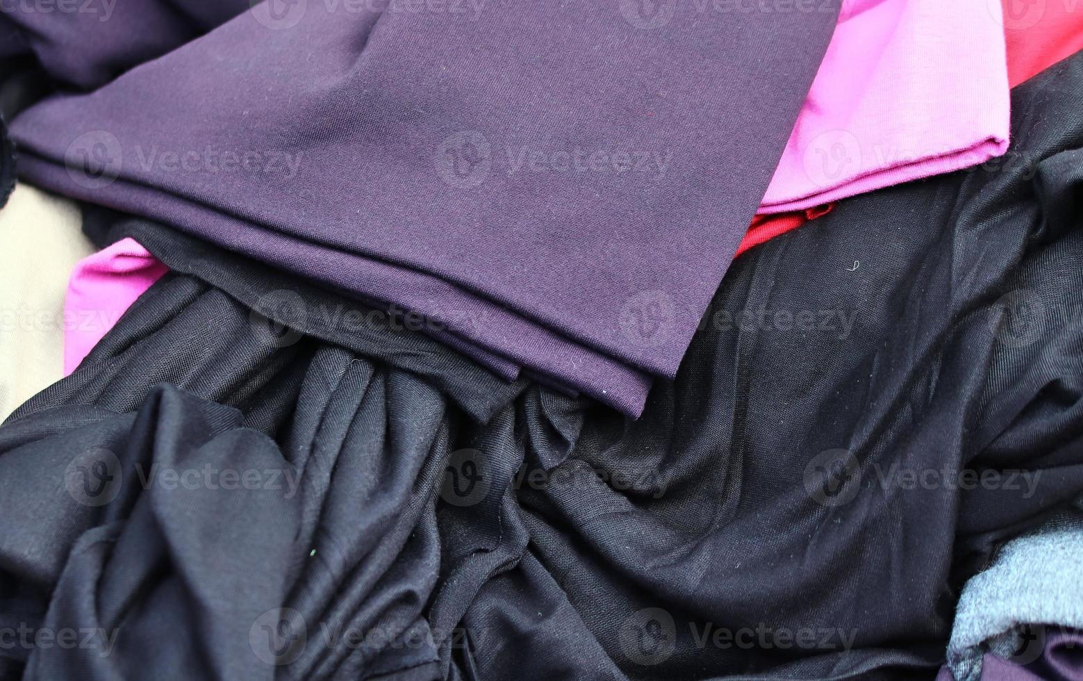 Detailed close up view on samples of cloth and fabrics in different colors found at a fabrics market photo