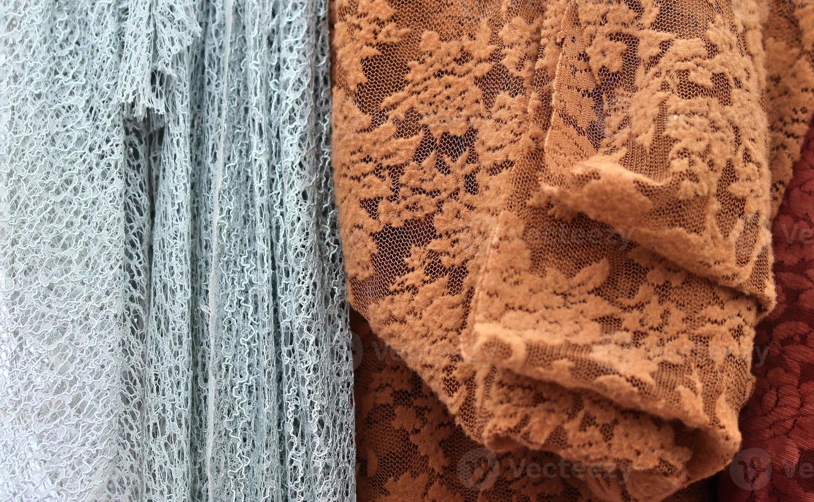 Detailed close up view on samples of cloth and fabrics in different colors found at a fabrics market photo