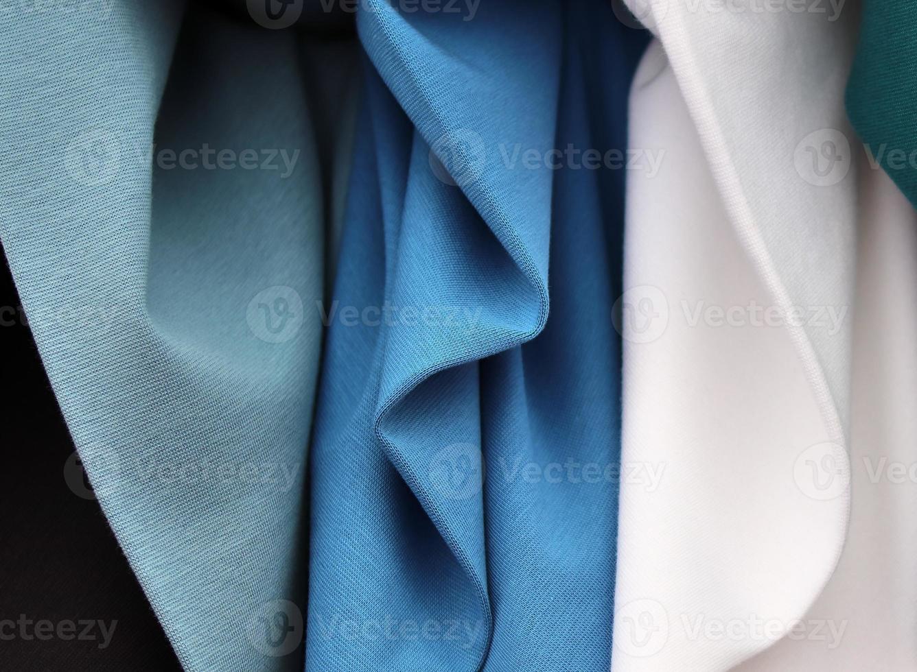 Detailed close up view on samples of cloth and fabrics in different colors found at a fabrics market photo