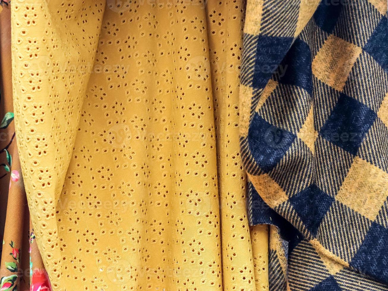 Detailed close up view on samples of cloth and fabrics in different colors found at a fabrics market photo