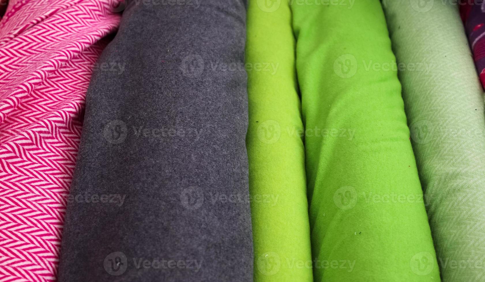 Detailed close up view on samples of cloth and fabrics in different colors found at a fabrics market photo