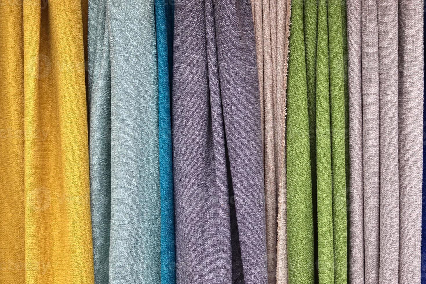 Detailed close up view on samples of cloth and fabrics in different colors found at a fabrics market photo