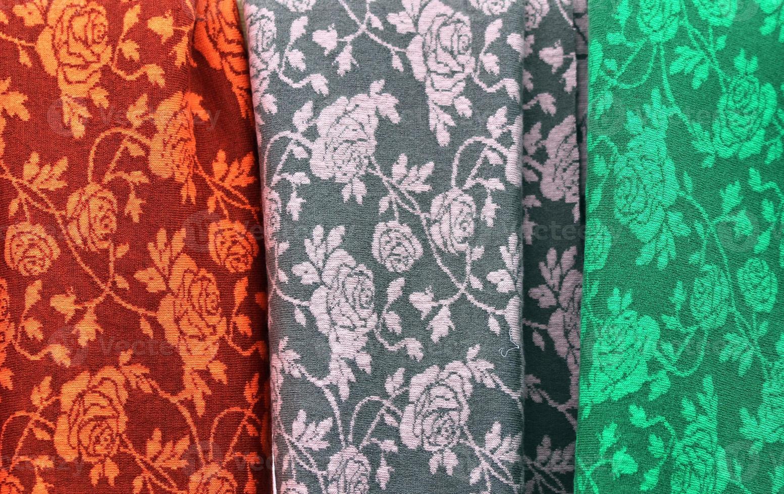 Detailed close up view on samples of cloth and fabrics in different colors found at a fabrics market photo