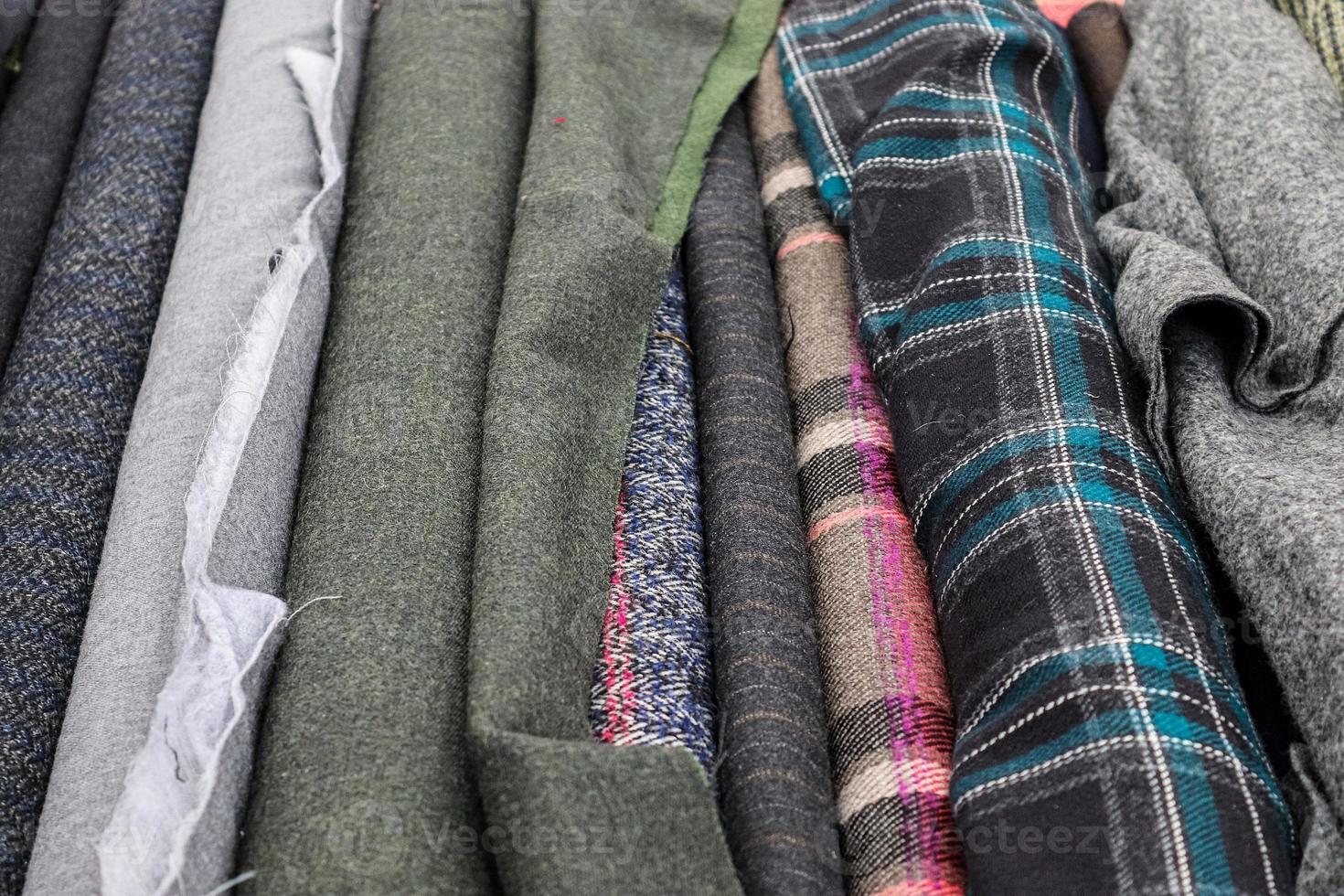 Detailed close up view on samples of cloth and fabrics in different colors found at a fabrics market photo