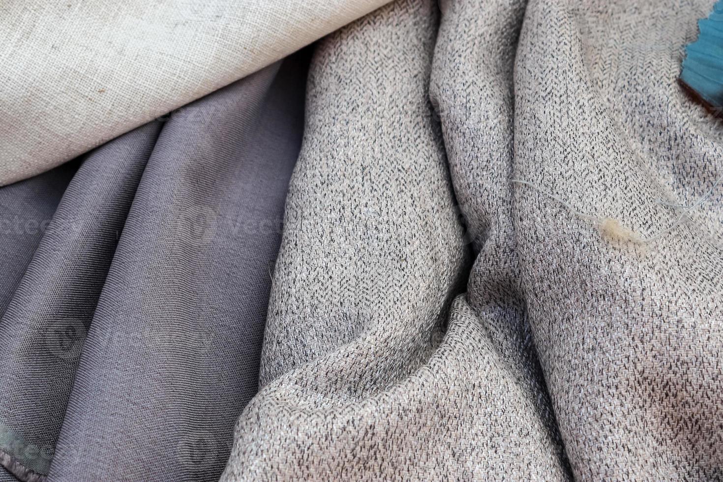 Detailed close up view on samples of cloth and fabrics in different colors found at a fabrics market photo