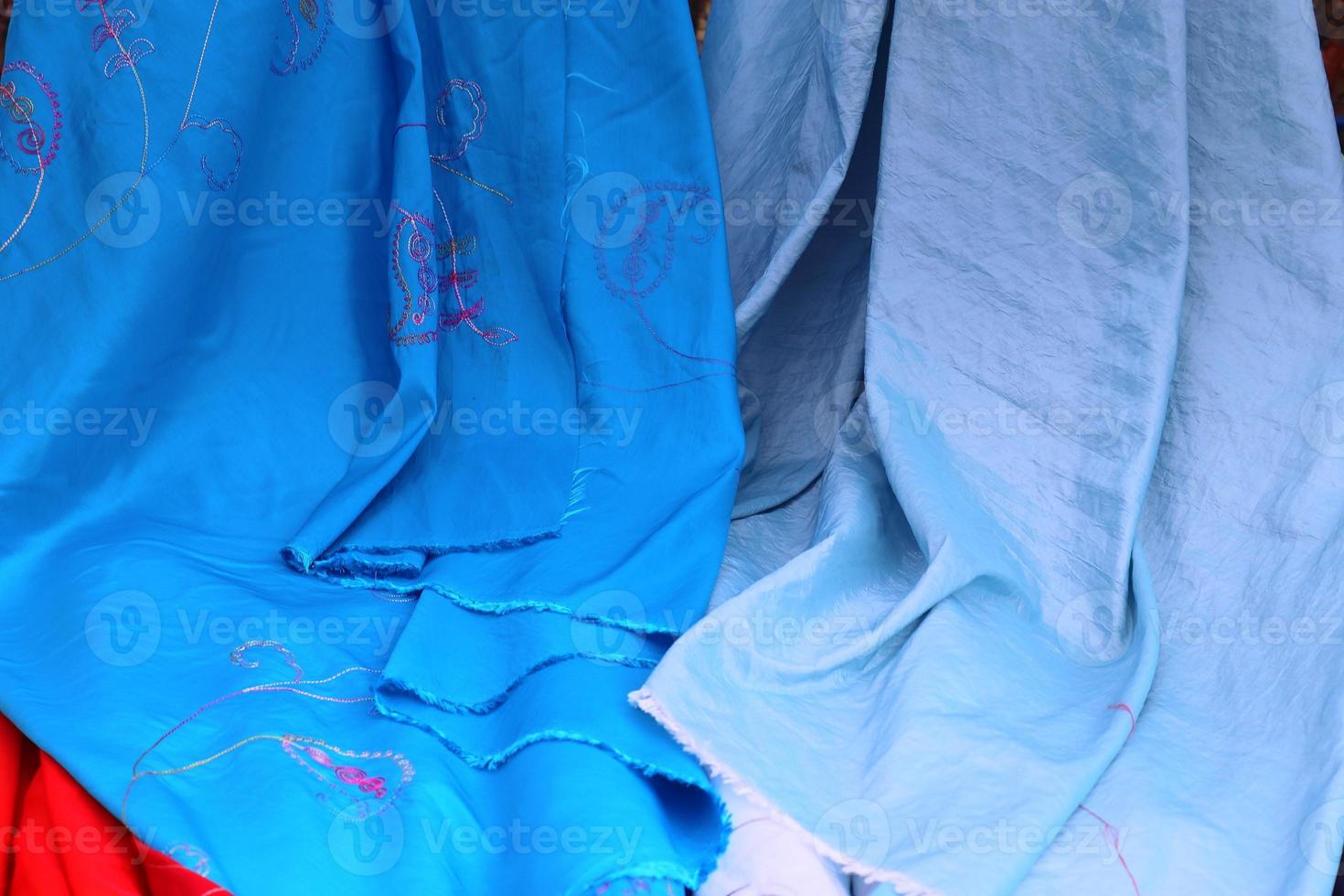 Detailed close up view on samples of cloth and fabrics in different colors found at a fabrics market photo