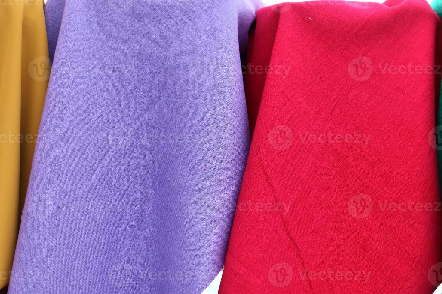 Detailed close up view on samples of cloth and fabrics in different colors found at a fabrics market photo
