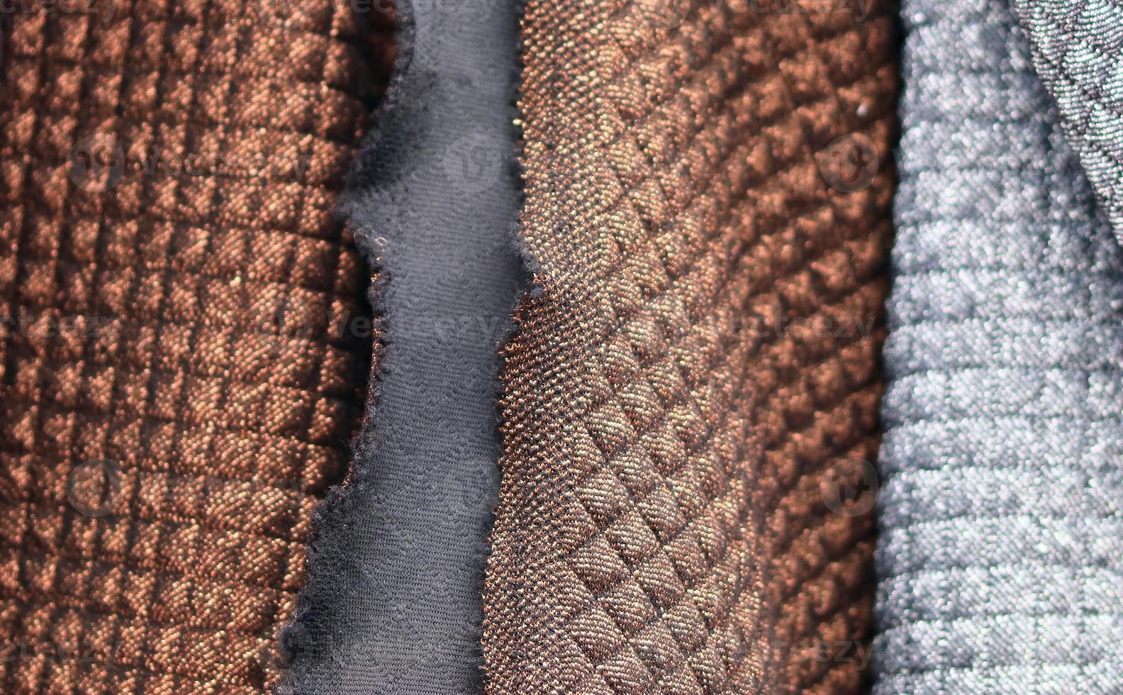 Detailed close up view on samples of cloth and fabrics in different colors found at a fabrics market photo