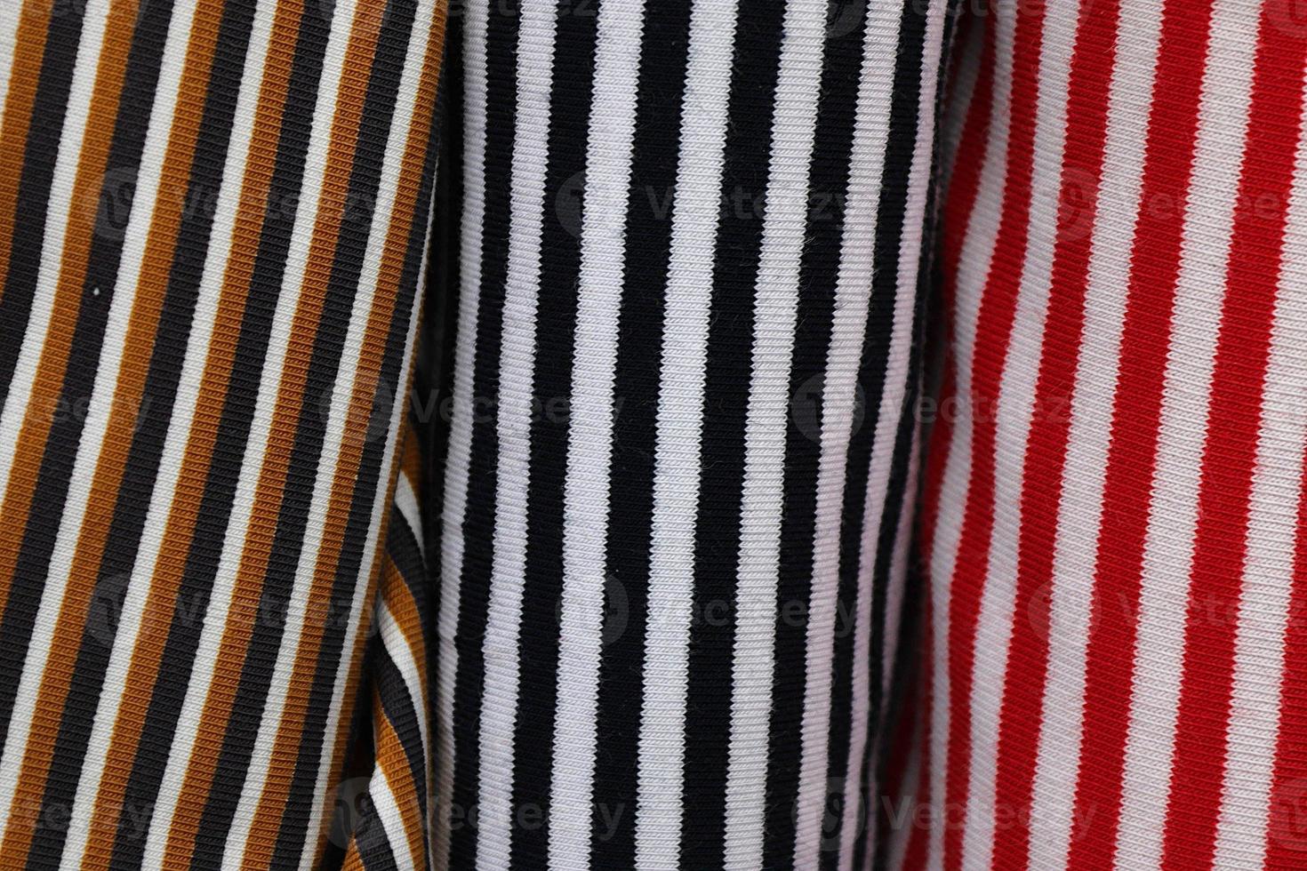 Detailed close up view on samples of cloth and fabrics in different colors found at a fabrics market photo