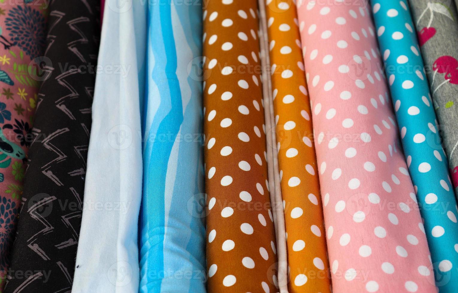 Detailed close up view on samples of cloth and fabrics in different colors found at a fabrics market photo