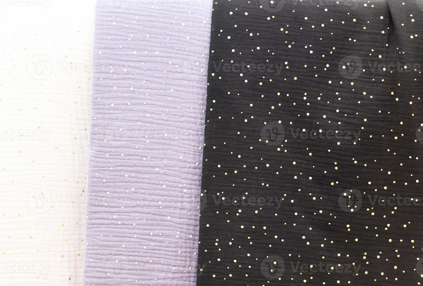 Detailed close up view on samples of cloth and fabrics in different colors found at a fabrics market photo