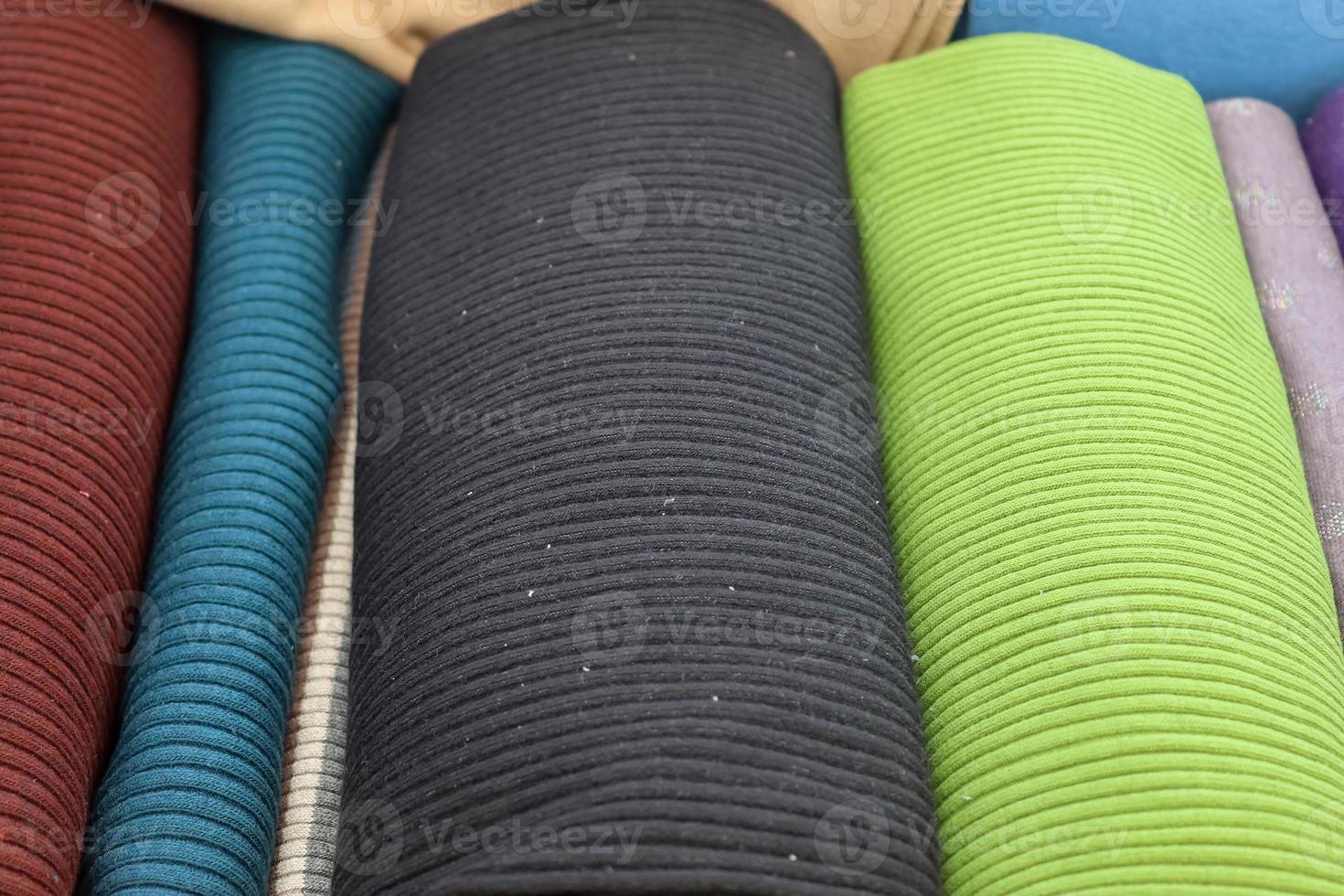Detailed close up view on samples of cloth and fabrics in different colors found at a fabrics market photo