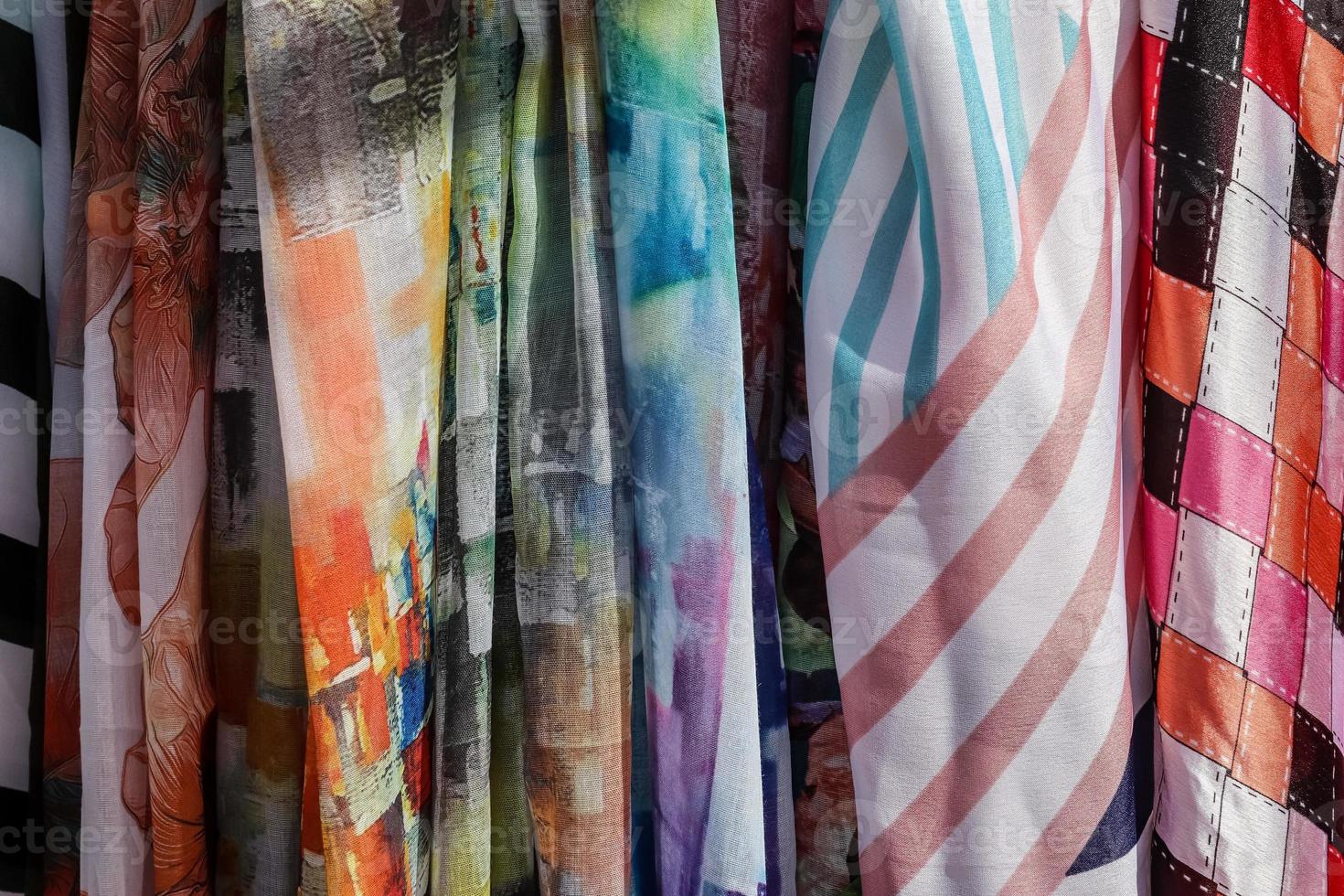 Detailed close up view on samples of cloth and fabrics in different colors found at a fabrics market photo