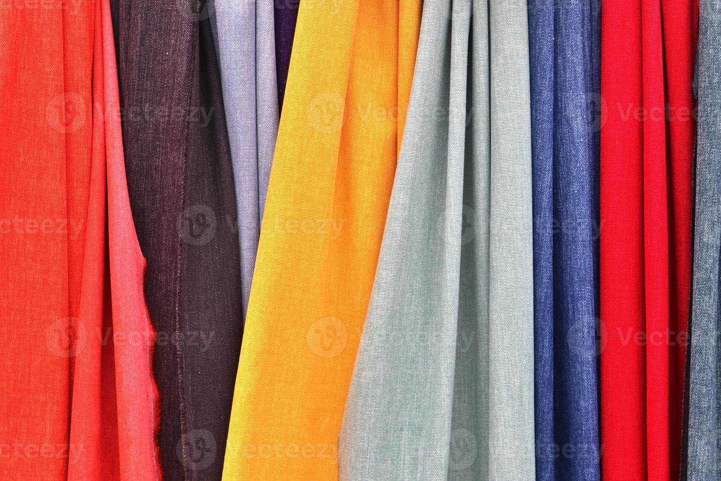 Detailed close up view on samples of cloth and fabrics in different colors found at a fabrics market photo