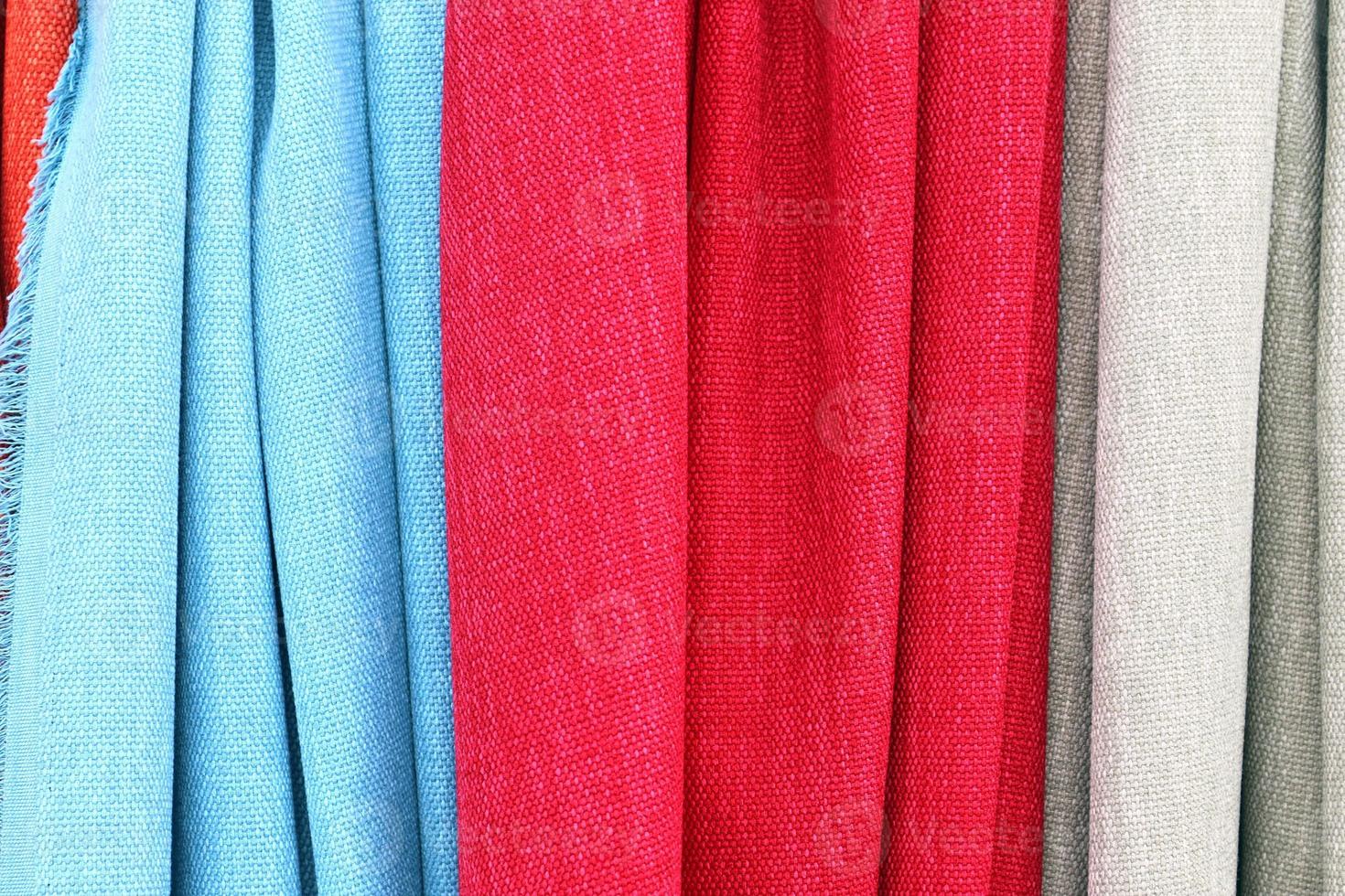 Detailed close up view on samples of cloth and fabrics in different colors found at a fabrics market photo