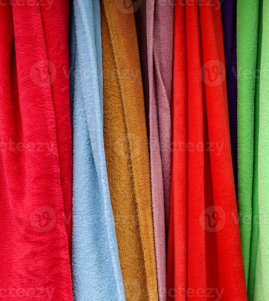 Detailed close up view on samples of cloth and fabrics in different colors found at a fabrics market photo