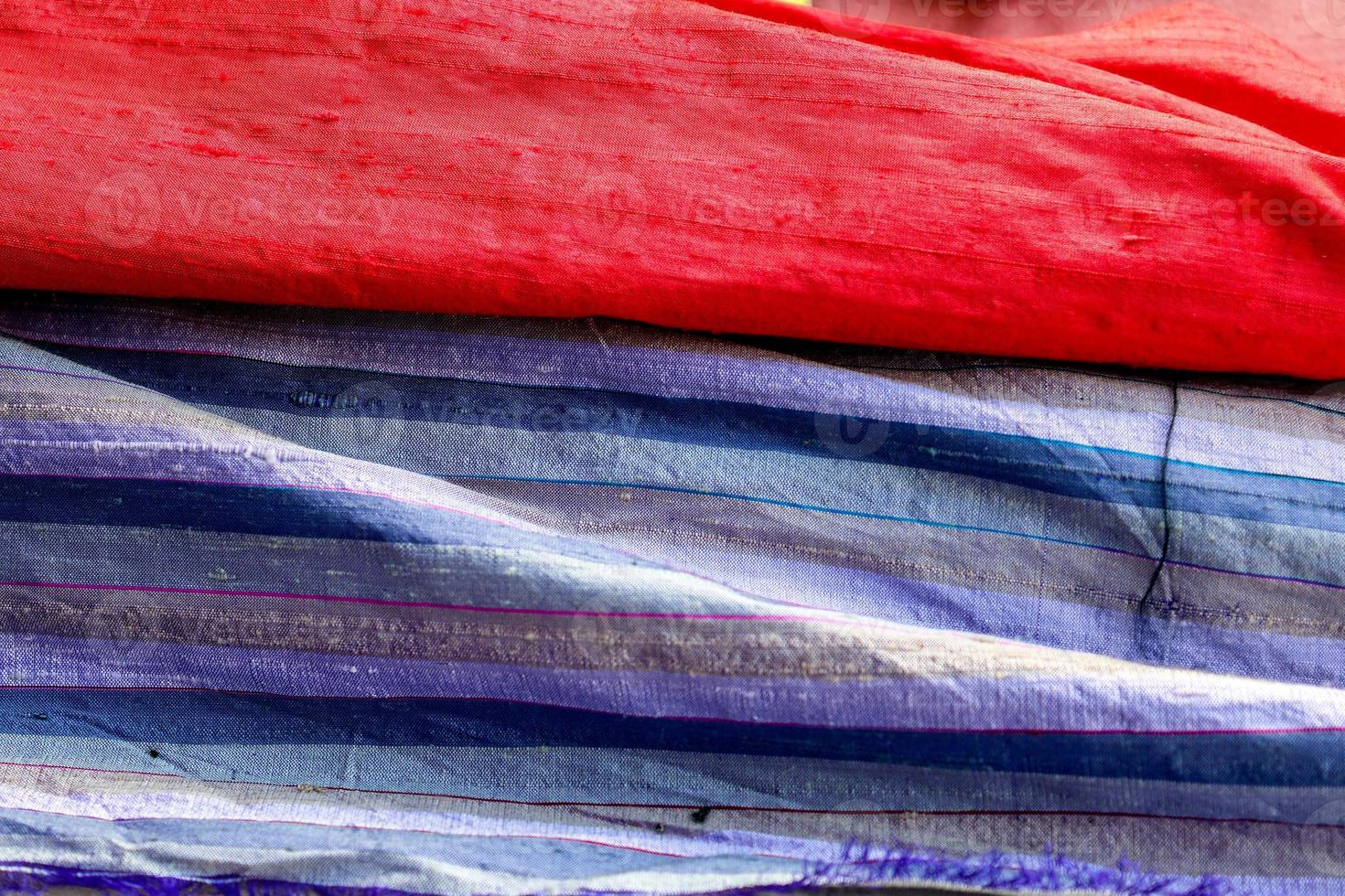 Detailed close up view on samples of cloth and fabrics in different colors found at a fabrics market photo