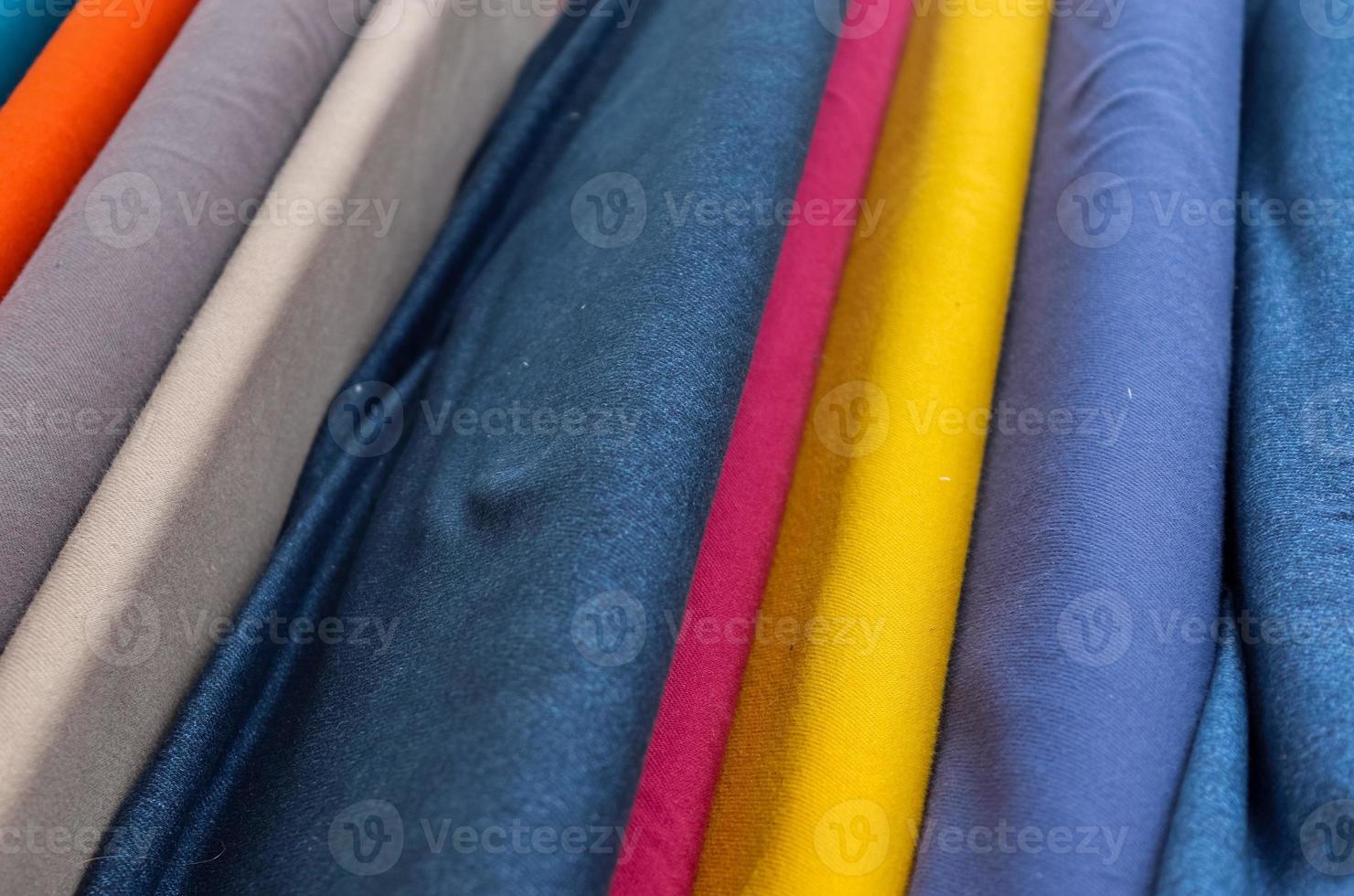 Detailed close up view on samples of cloth and fabrics in different colors found at a fabrics market photo