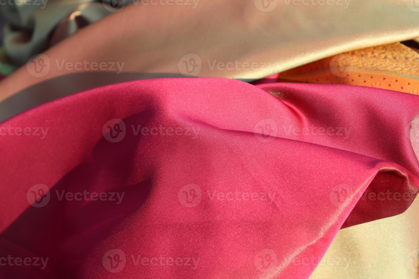Detailed close up view on samples of cloth and fabrics in different colors found at a fabrics market photo
