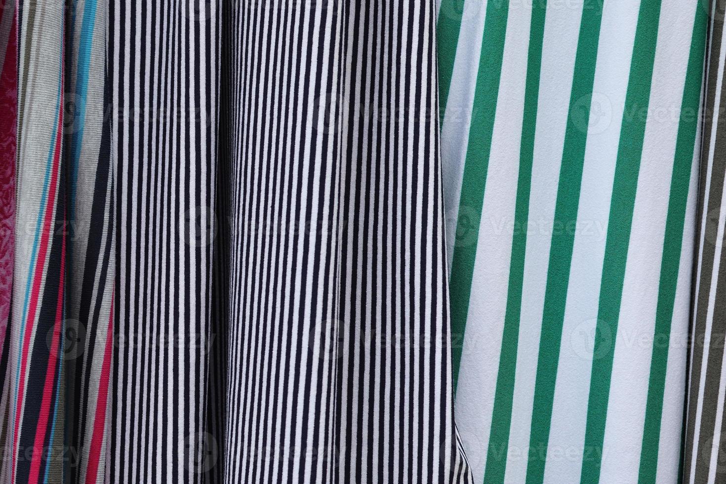 Detailed close up view on samples of cloth and fabrics in different colors found at a fabrics market photo