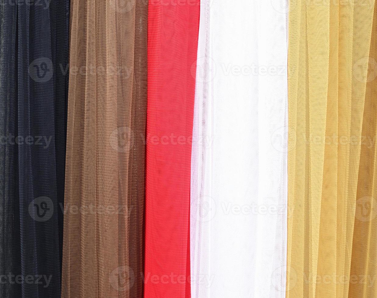 Detailed close up view on samples of cloth and fabrics in different colors found at a fabrics market photo