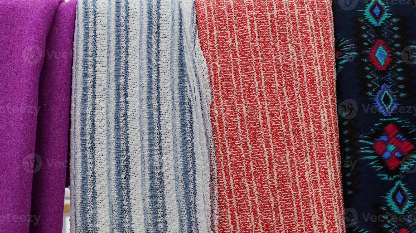 Detailed close up view on samples of cloth and fabrics in different colors found at a fabrics market photo