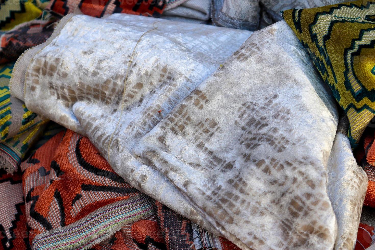 Detailed close up view on samples of cloth and fabrics in different colors found at a fabrics market photo