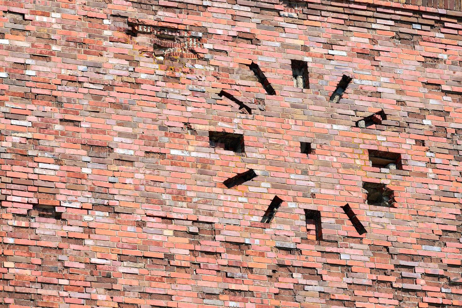 Abandoned old vintage red brick wall with round clock on facade, masonry fragment photo