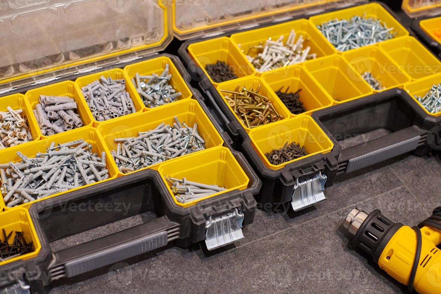 Storage boxes on floor with screws, nuts, bolts, nails and other small tools for handyman, close up photo