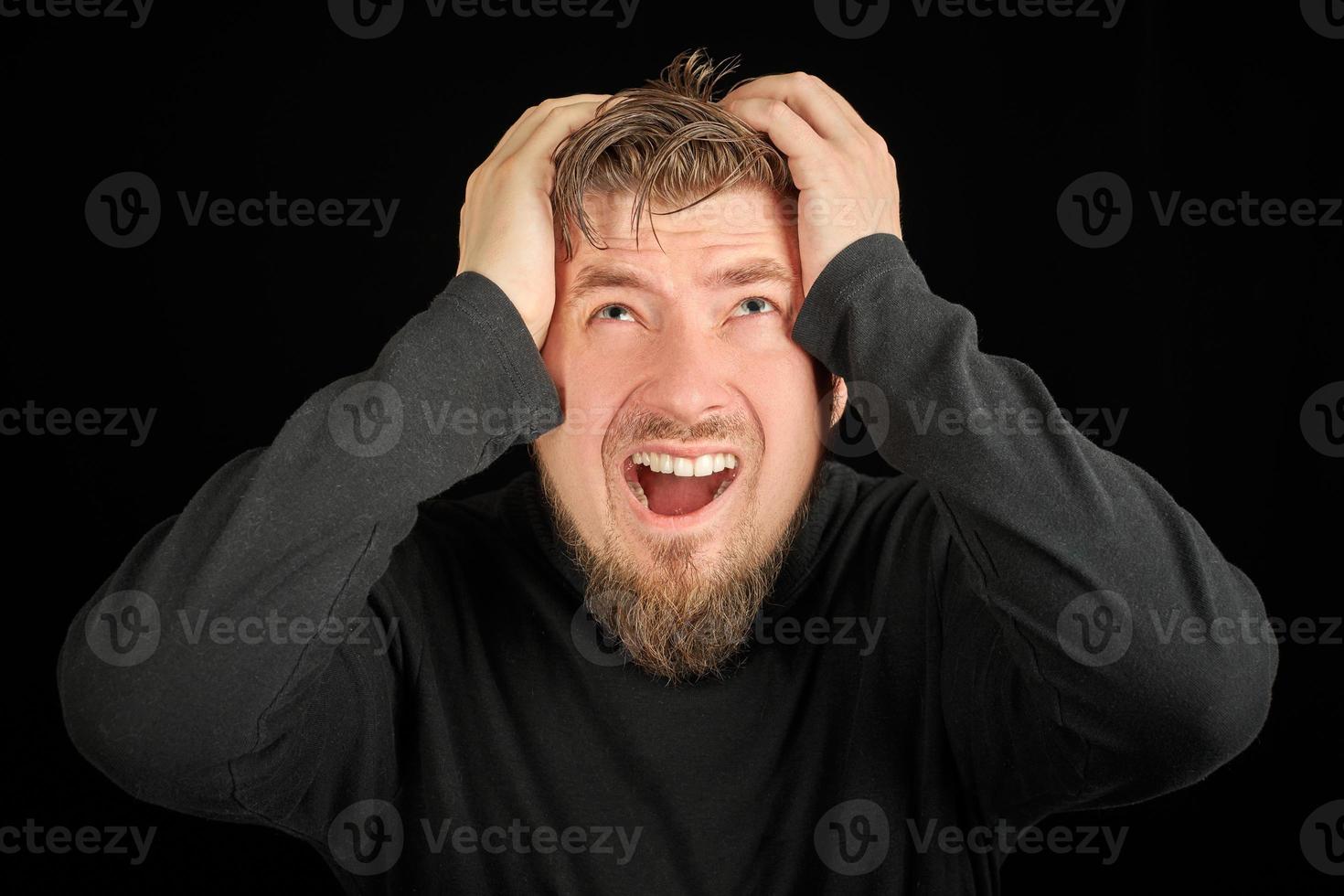 Overworking, head pain concept. Young guy in black polo neck sweater. photo