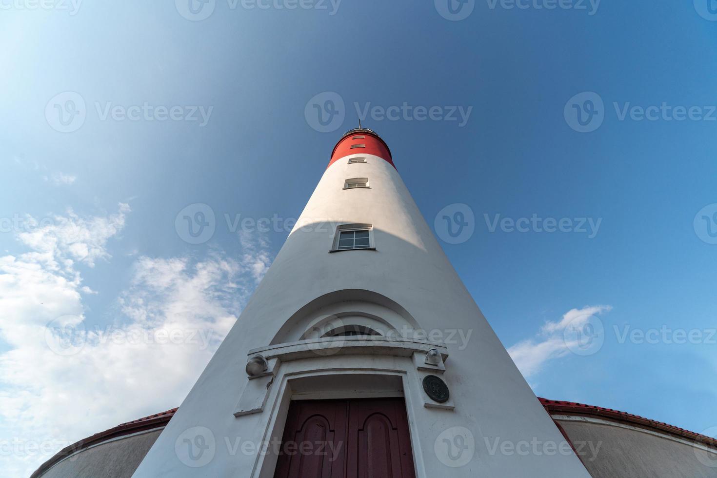 faro báltico, colores blancos rojos, vista inferior. el faro ruso más occidental en la ciudad de baltiysk. hermoso clima soleado. foto