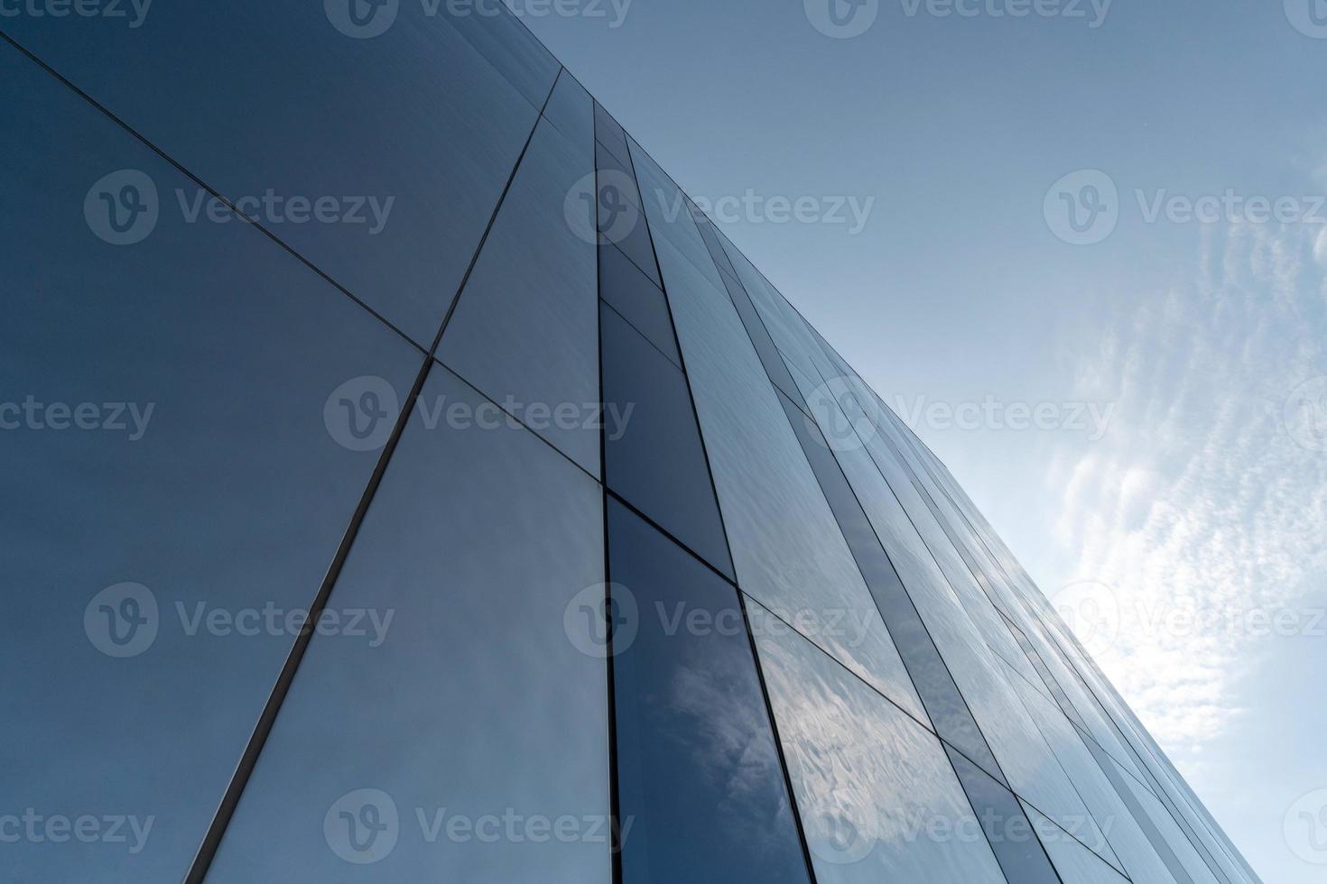 Modern mirror wall decoration of business center, copy space. Bottom view to texture of exterior design. Contemporary pattern of buildings. Looking up. photo