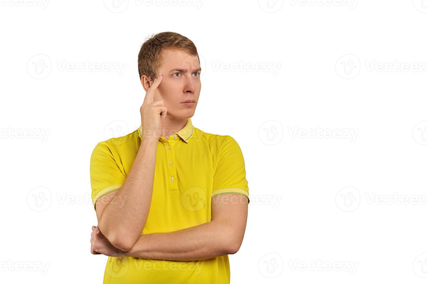 hombre reflexivo con camiseta amarilla mirando a la derecha, fondo blanco, reflexión filosófica foto