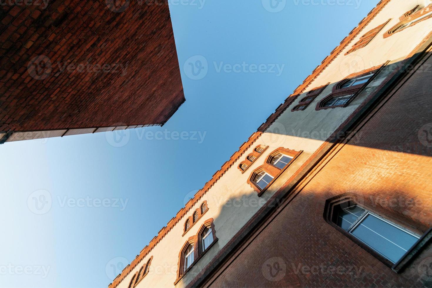 Old barracks building and boiler room pipe, perspective bottom view. Historic building from the last world war II photo