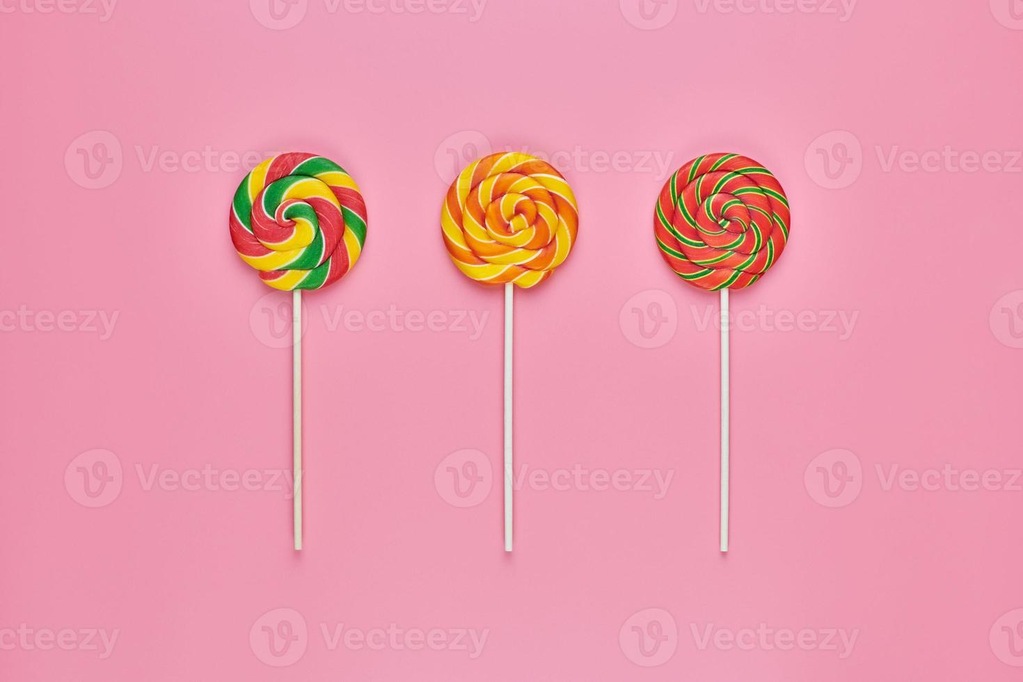 Sweet lollipops on pink background photo