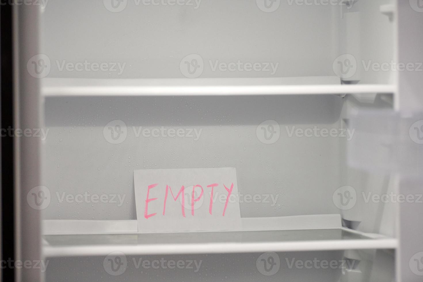 Empty refrigerator concept. Empty shelves of new refrigerator. Weight loss diet concept. photo