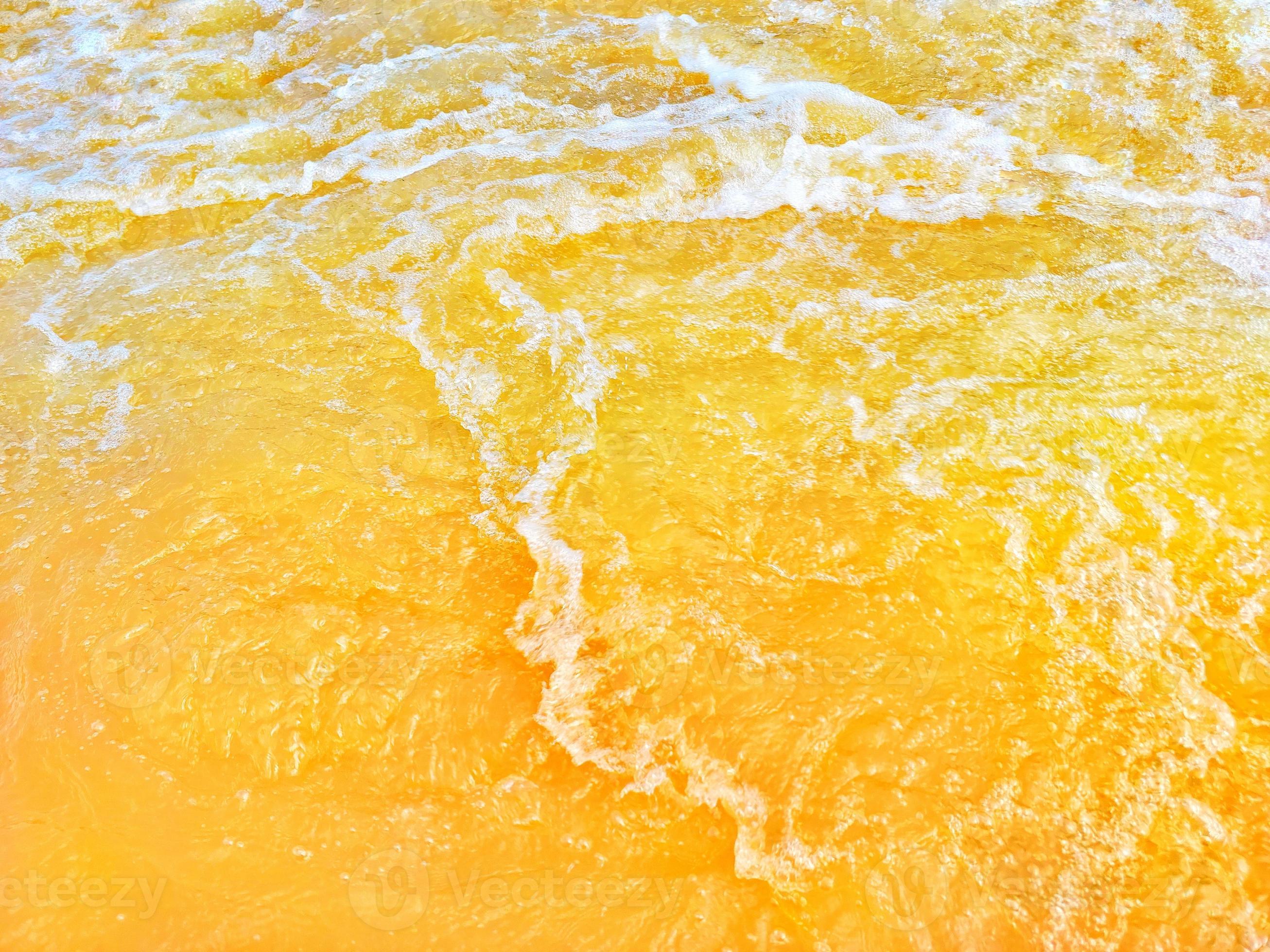 Defocus blurred transparent orange colored clear calm water surface