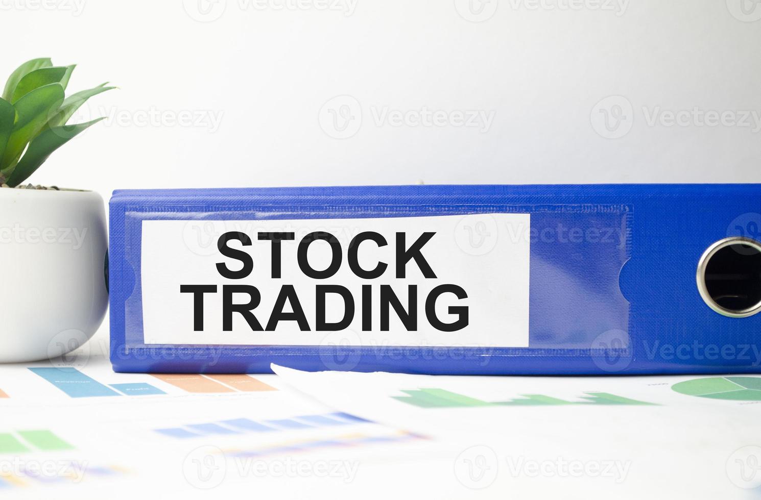 word stock trading on blue folder and charts photo