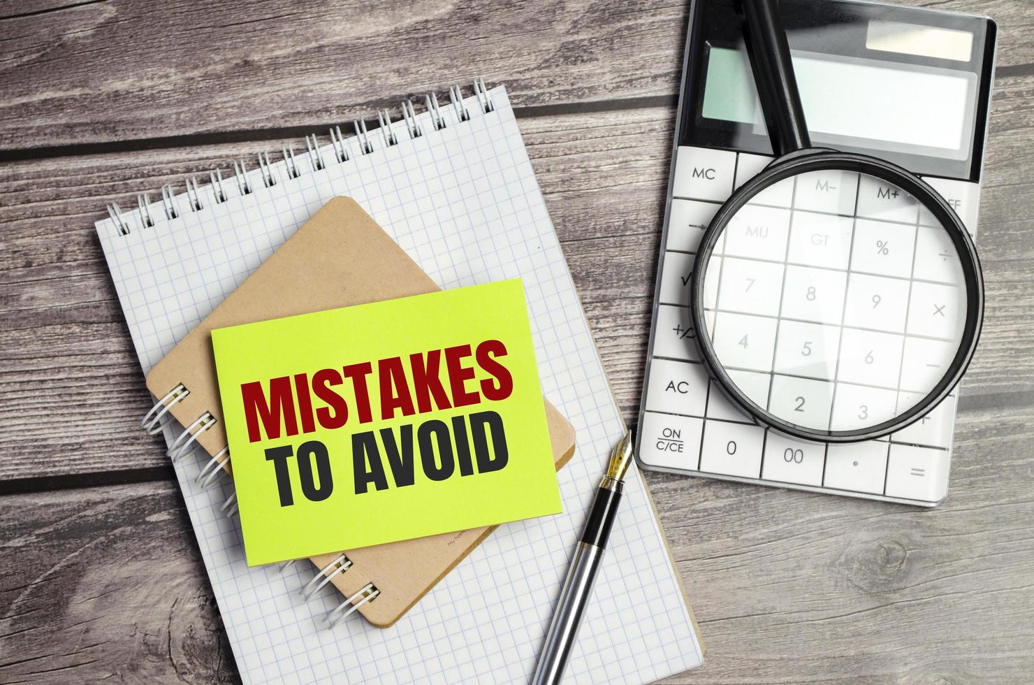 mistakes to avoid text on the green sticker and wooden background photo