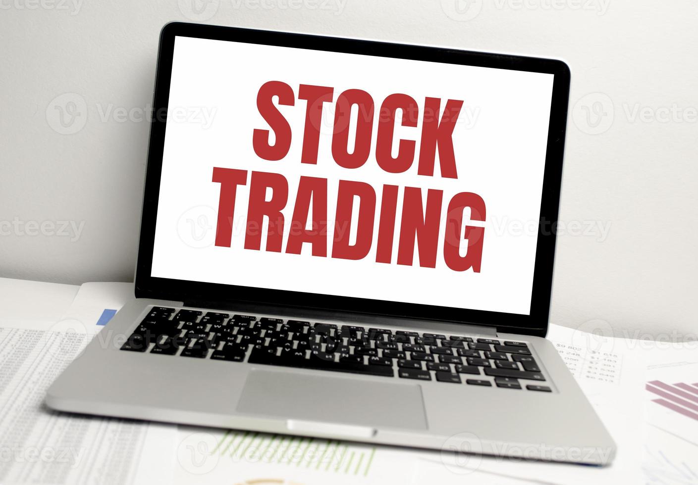 stock trading words on laptop display and charts photo