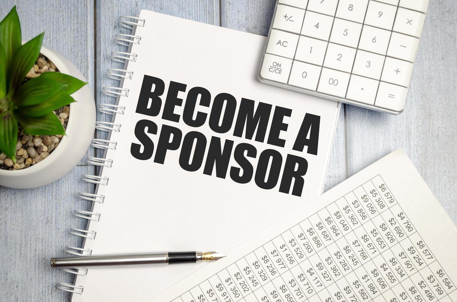 BECOME A SPONSOR word on notepad with glasses and chart photo