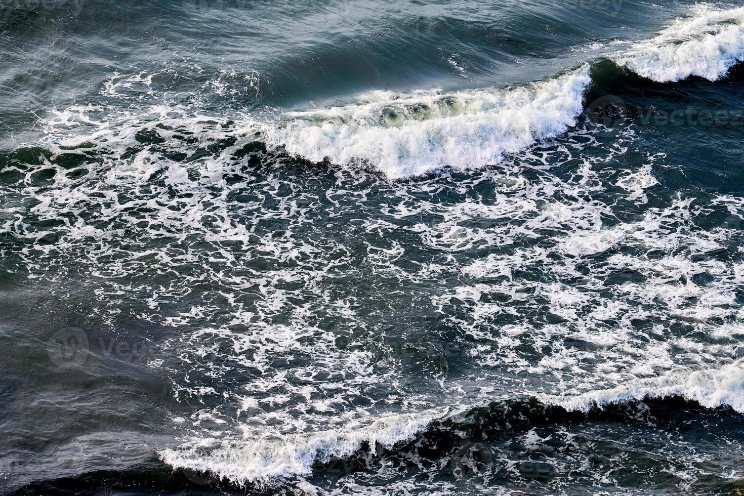 Deep blue sea waters splashing with foamy waves, dark blue wavy ocean water surface, stormy sea photo