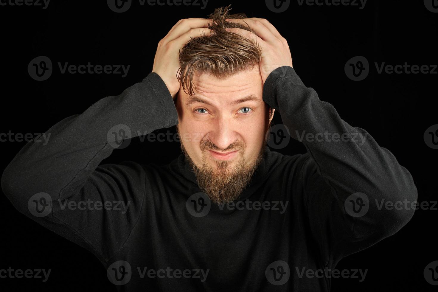 Overworking, head pain concept. Young guy in black polo neck sweater. photo