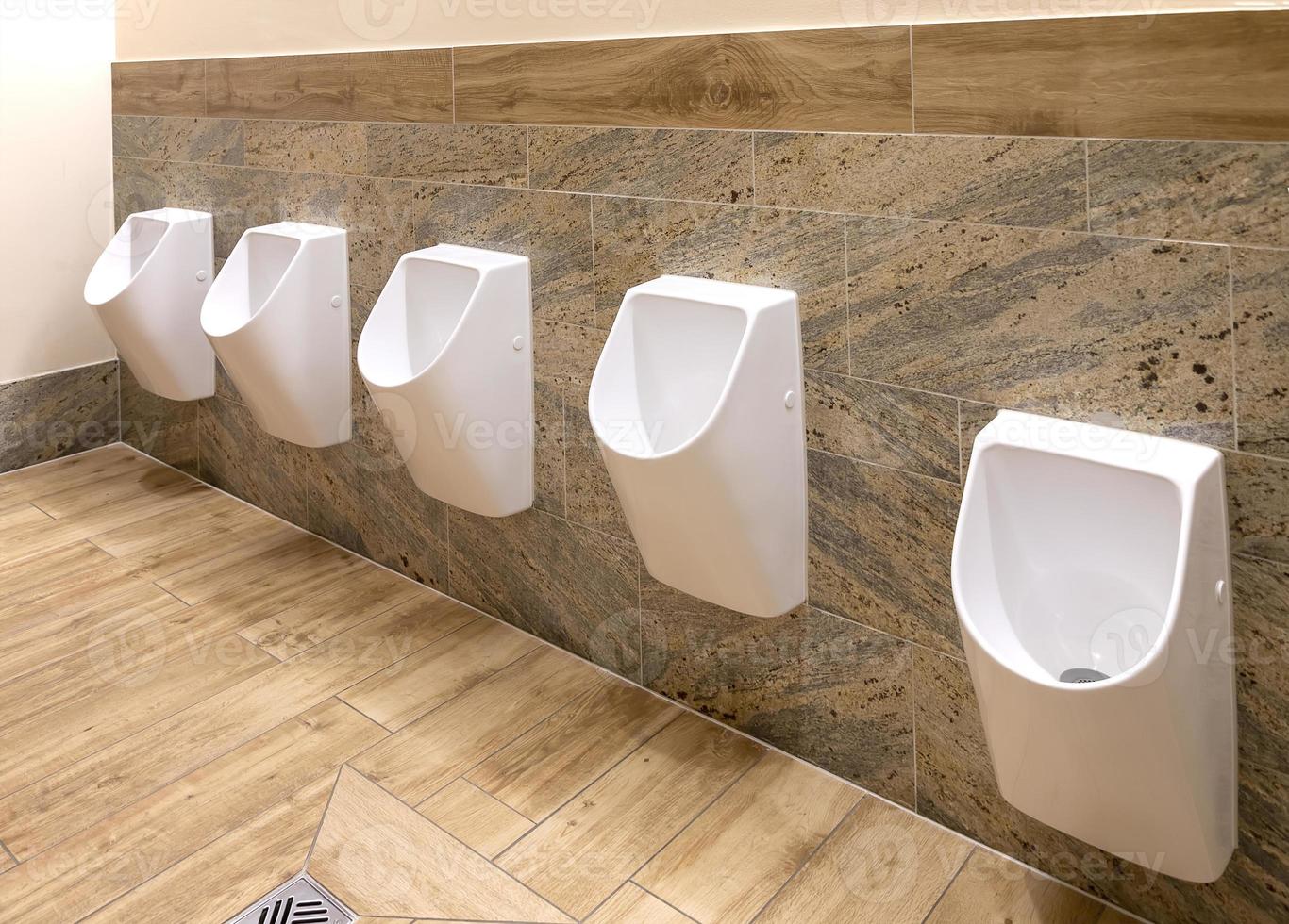 White urinals in men's bathroom, the design of white ceramic urinals for men in the toilet room. public men toilet room, WC. photo