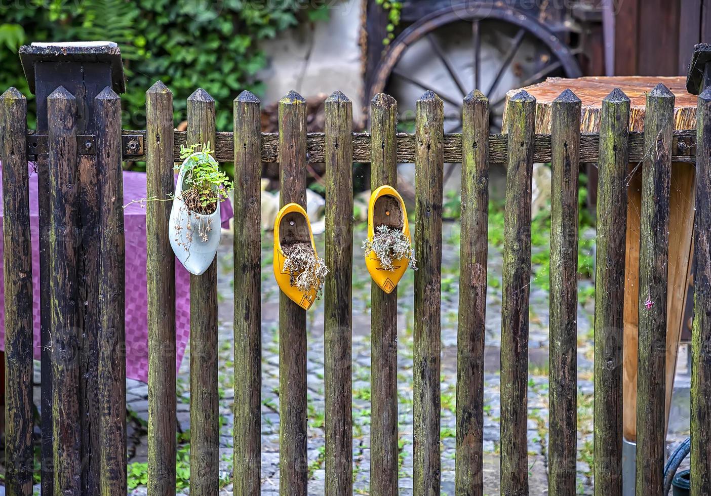 The old traditional shoes hang on the fence like decoration, noise photo